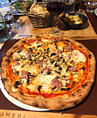 Wood-fired pizza with ham and mushrooms