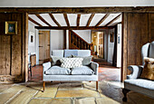 Sitting area with light blue sofa and decorative pillows in a rustic half-timbered house