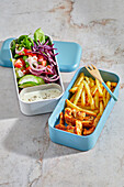 Lunch box with chicken, fries and salad