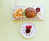 Hamburger mit Pommes und Kakaocreme mit Himbeeren