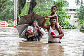 Family walking through floodwater, Satkania Upazila, Bangladesh