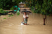 Man collecting drinking water in floodwater, Satkania Upazila, Bangladesh