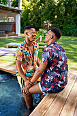 Young gay male couple relaxing in swimming pool