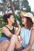 Lesbian couple applying sunscreen