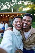 Happy young gay male couple taking selfie