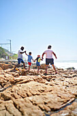 Family holding hands on seaside rocks