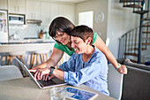 Happy lesbian couple using laptop