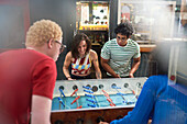 Young friends playing foosball