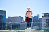 Young man with smart phone on ledge