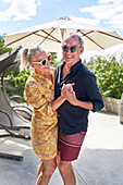 Senior couple dancing on sunny patio