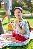 Boy with Down syndrome on picnic blanket in park