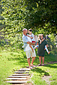 Family walking on footpath in sunny park