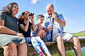 Family with binoculars fishing on summer pier
