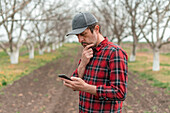 Farmer using smartphone in orchard