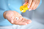 Man pouring pills into hand