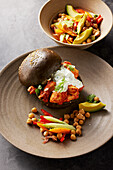 Butter chicken burger with garlic sauce on chickpea salad