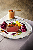 Saddle of venison in purple curry sauce with red cabbage rolls and pumpkin puree