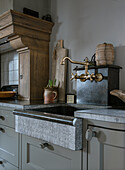 Rustic kitchen with unusual stone sink and brass faucet