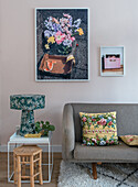 Modernes Wohnzimmer mit floraler Wanddekoration und bunten Blumenkissen