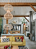 Loft living room with wooden beams, yellow sofa and rattan lamps