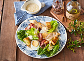 Caesar salad with hard-boiled eggs and bacon