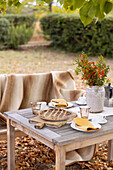 Coffee table with orange crostata in the autumn garden
