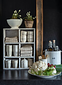 Country kitchen with shelf full of white ceramics and terry towels