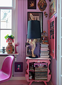 Pink bedside table with record collection, stack of books and original golden rabbit lamp