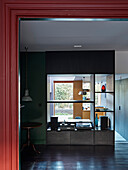 View of open-plan living room with dark green walls and central room divider