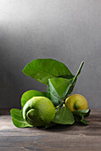 Lemons with leaves on a wooden surface