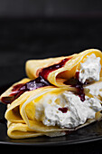 Pancakes filled with cream and berry sauce