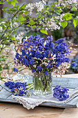 Bouquet of rock pear (Amelanchier), grape hyacinth (Muscari) and hyacinth (Hyacinthus) on patio table