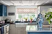 Country-style kitchen with blue cabinet fronts and hydrangea-coloured decoration