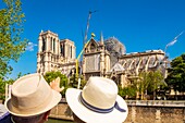 France,Paris,area listed as World heritage by UNESCO,Ile de la Cite,2 tourists watch Notre Dame cathedral
