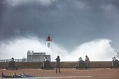 France,Vendee,Les Sables d'Olonne,people watching the harbour channel lighthouse in Miguel storm