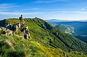France,Cantal,Regional Natural Park of the Auvergne Volcanoes,monts du Cantal,Cantal mounts,hiker on the slopes of Puy Mary,in the background the Sancy Massif