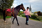 France,Calvados,Pays d'Auge,La Roque Baignard,young girl going out to ride