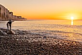 France,Somme,Picardy Coast,Ault,twilight at the foot of the cliffs that stretch towards Le Tréport and Normandy,children are playing on the rocks