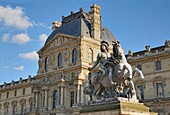 France,Paris,area listed as World Heritage by UNESCO,the Equestrian statue of Louis XIV and the facades of the Cour Napoleon of the Louvre Museum