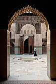 Morocco,Woman walking across courtyard of Medersa Bou Inania,Fez