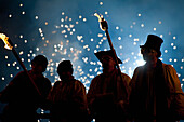 UK,England,Als Geistliche verkleidete Menschen an einem Stand mit Feuerwerk hinter ihnen bei der Newick bonfire night,East Sussex