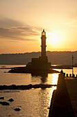 Greece,Crete,Silhouette of lighthouse at harbor entrance at dawn,Chania