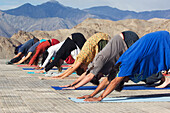 Yogagruß an die Sonne vor der Shanti (Peace) Stupa oberhalb von Leh. Ladakh, Provinz Jammu und Kaschmir, Indien