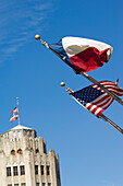 Altes San-Antonio-Nachrichtengebäude im Hintergrund mit Stars and Stripes (US-Flagge) und Lone Star (Texas-Flagge) im Vordergrund, San Antonio, Texas, USA