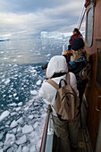 Visitors On A Midnight Cruise Around The Ilulissat Ice Fjord,One Of Unesco World Heritage Sites. Greenland.