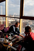Besucher spielen ein Brettspiel im 26. Stock der Reval Hotel Skyline Bar, bei Sonnenuntergang, Riga, Lettland.