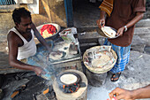 Herstellung von Chapatti Indisches Brot auf der Straße in der Nähe des New Market in der Nähe der Sudder Street, einem beliebten Viertel mit preiswerten Unterkünften für Rucksacktouristen in Kalkutta / Kolkata, der Hauptstadt des Bundesstaates Westbengalen, Indien, Asien.