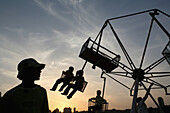 Kinder auf einem Rummelplatz bei Sonnenuntergang am Chowpatty Beach, Mumbai, Bundesstaat Maharashtra, Indien