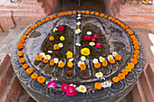 Indien,Bihar,Mit Blumen bedeckte Füße von Buddha außerhalb des Mahabodhi-Tempels,Bodhgaya