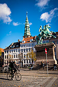 Dänemark,Radfahrer vor Bischof Absalon Reiterstandbild in Hojbro Plads und Ansichten von Nikolaj im Hintergrund,Kopenhagen